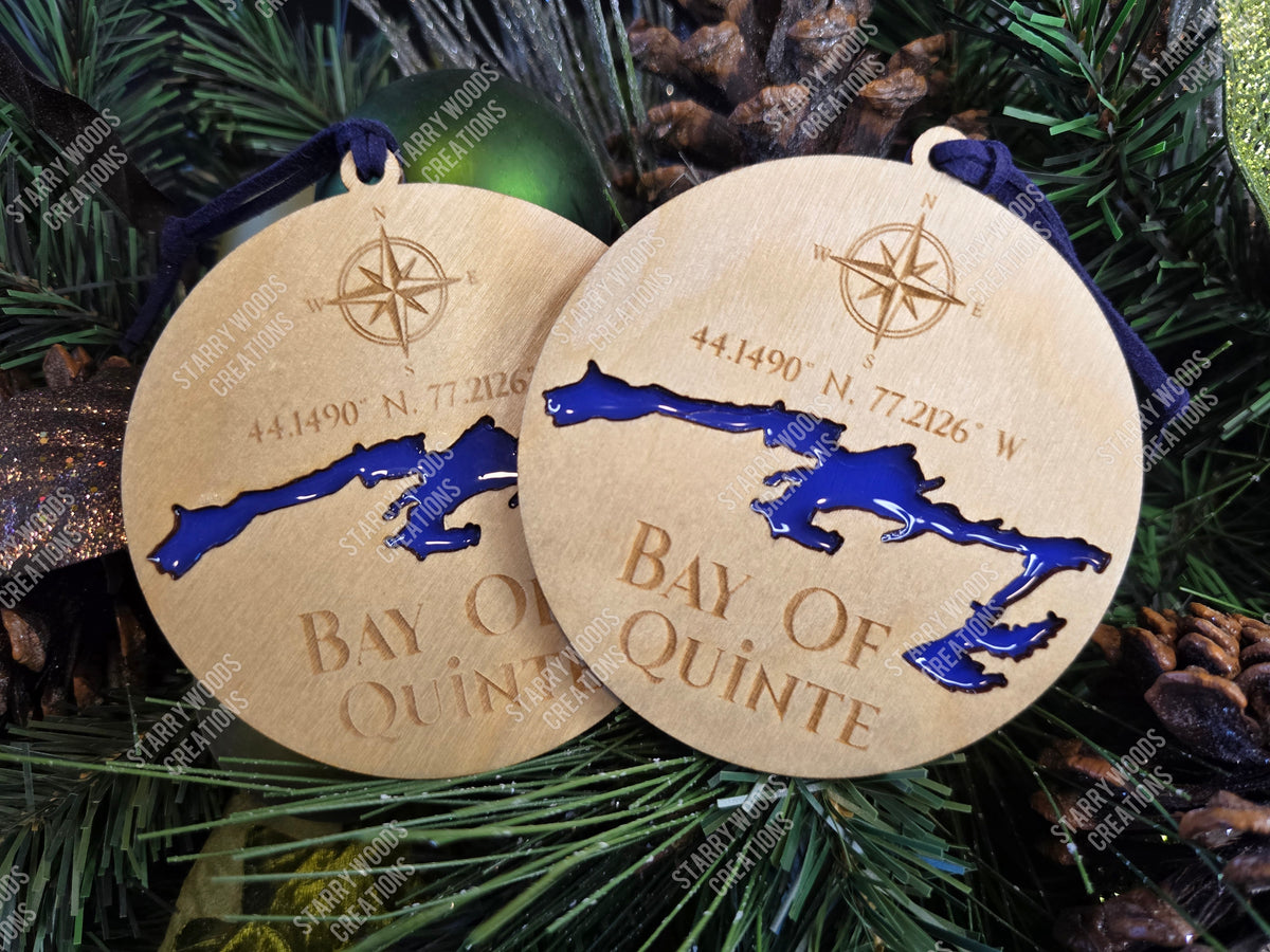 Two wooden ornaments with a Bay of Quinte, resin filled, design and coordinates on a Christmas tree, handmade in Quinte West.