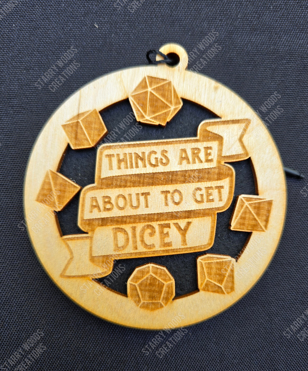 Wooden hanging air freshener with dice designs and 'Things are about to get dicey' text on a dark background