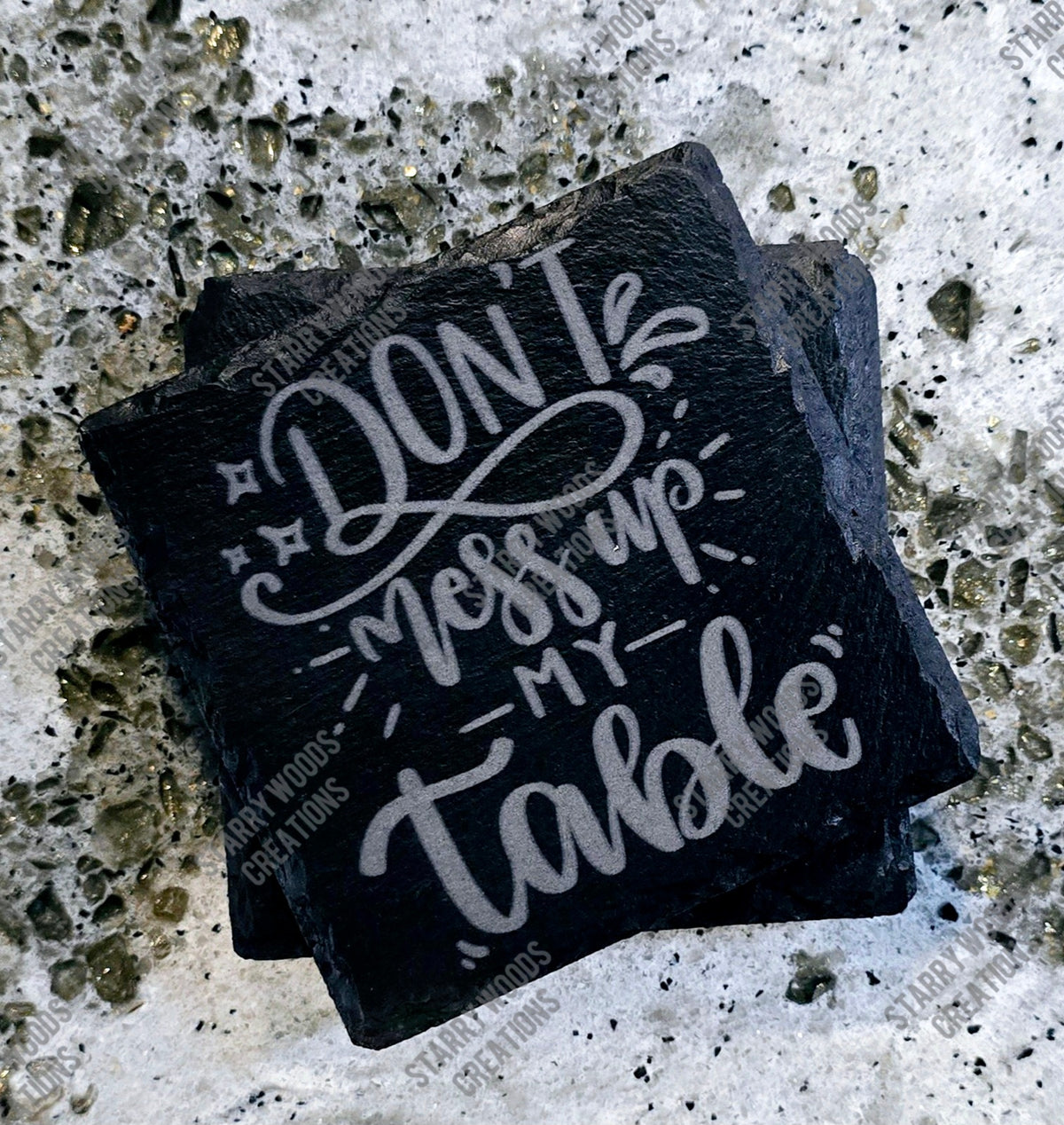 Square, black slate coasters with white text 'Don't mess up my table' 