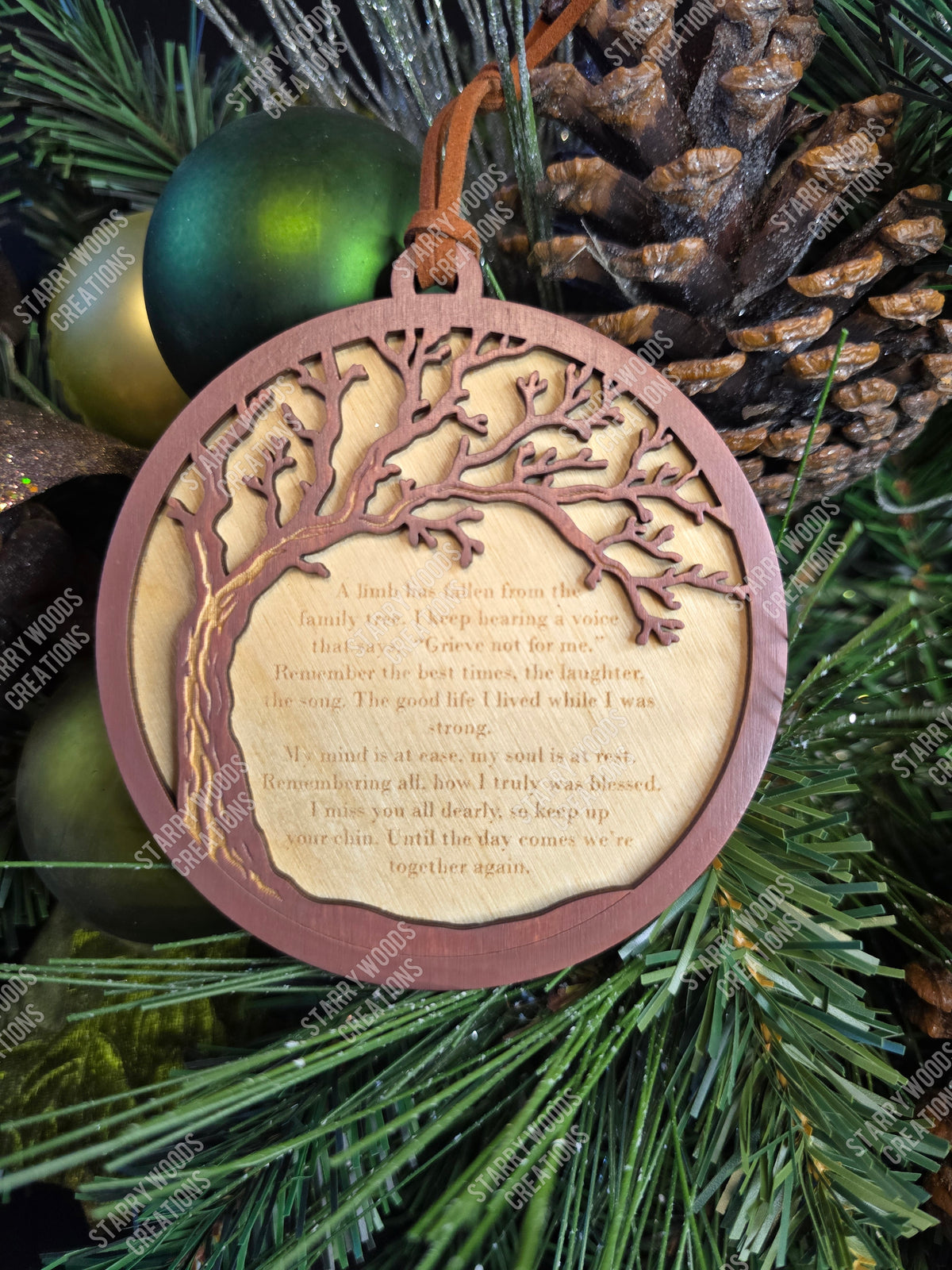 Decorative ornament with tree design and text from the "fallen limb" poem on a green Christmas tree background
