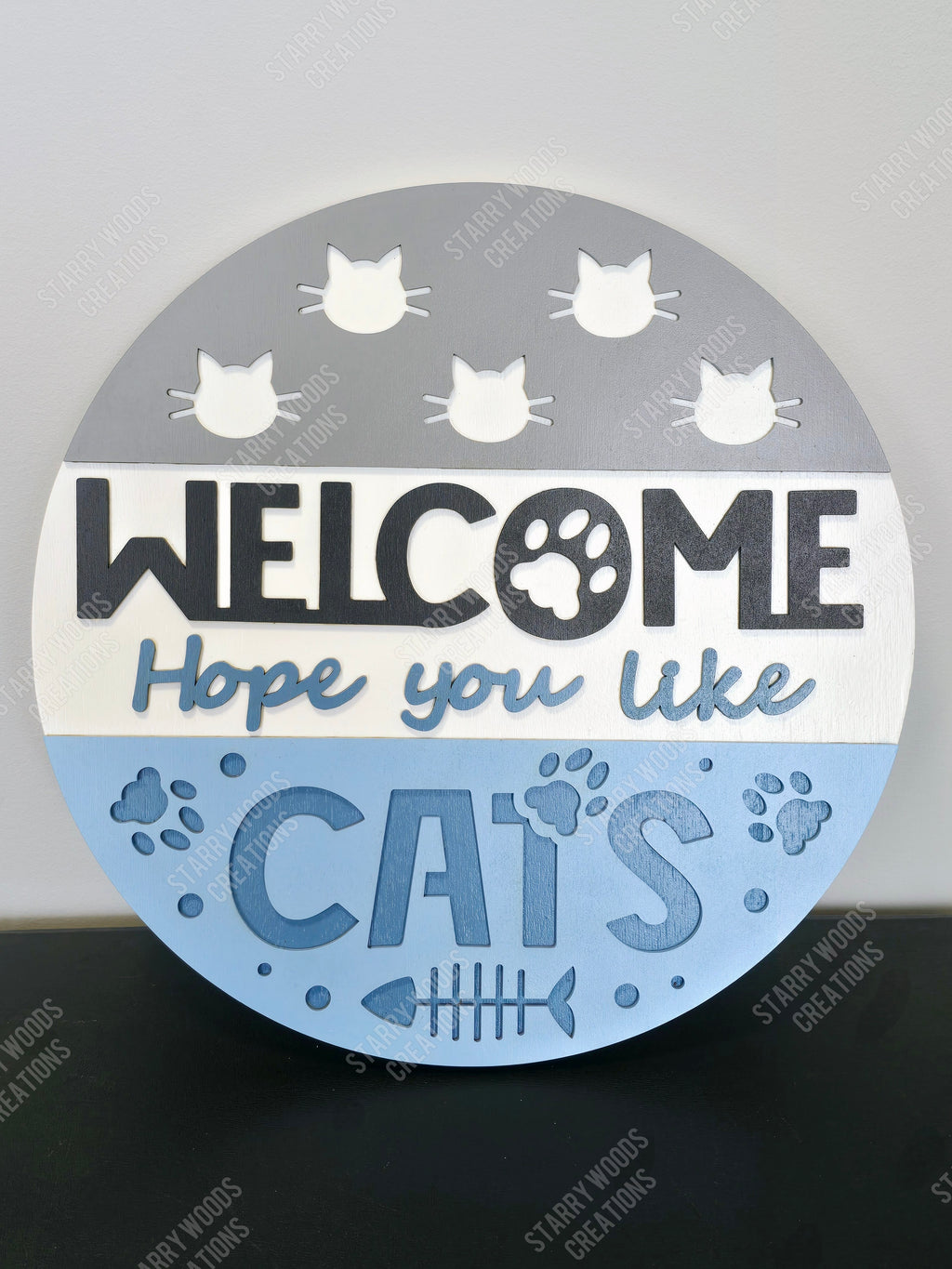 Round sign with 'Welcome, Hope you like cats' text and cat illustrations on a gray and blue background. Hamdmade in Ontario and customizable.