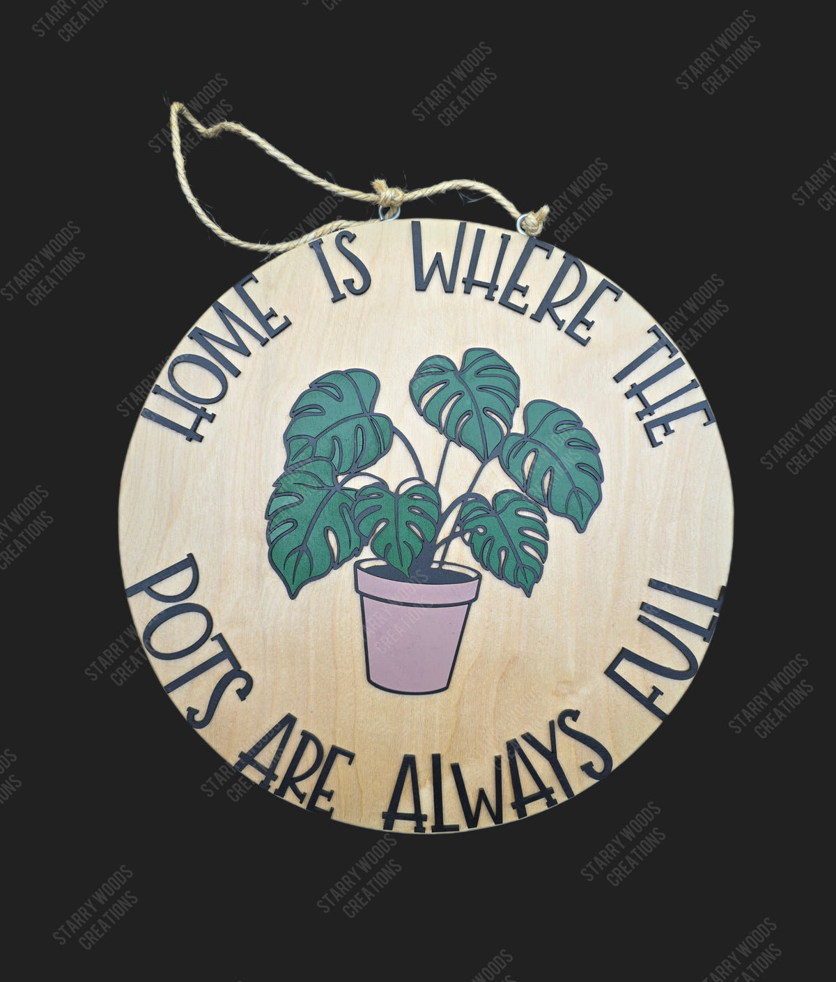 Round wooden sign with a monstera plant illustration and text reading "home is where the pots are always full" on a black background. Handmade in Quinte West and customizable.