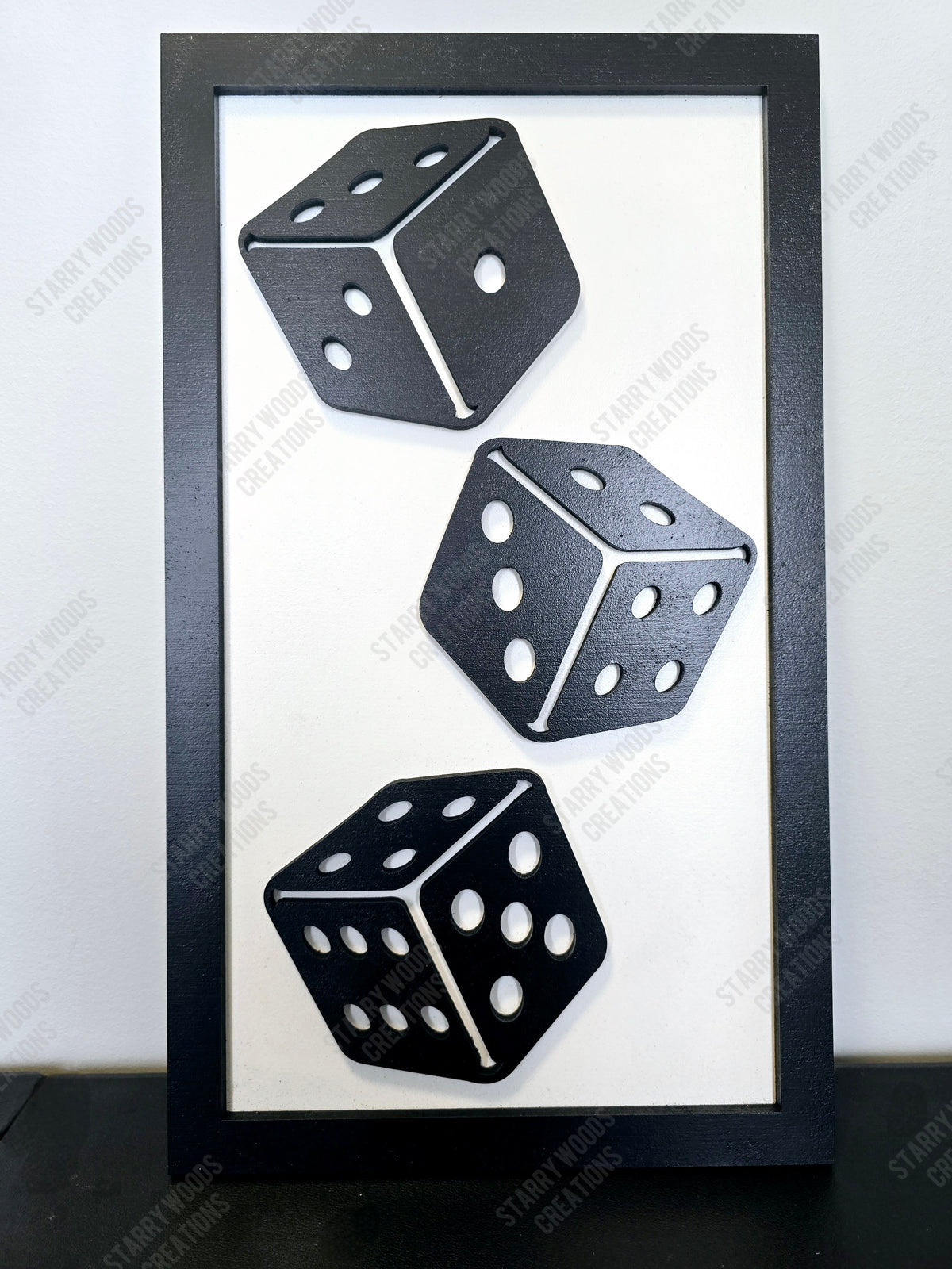 Three black dice with white dots in a black frame on a white background