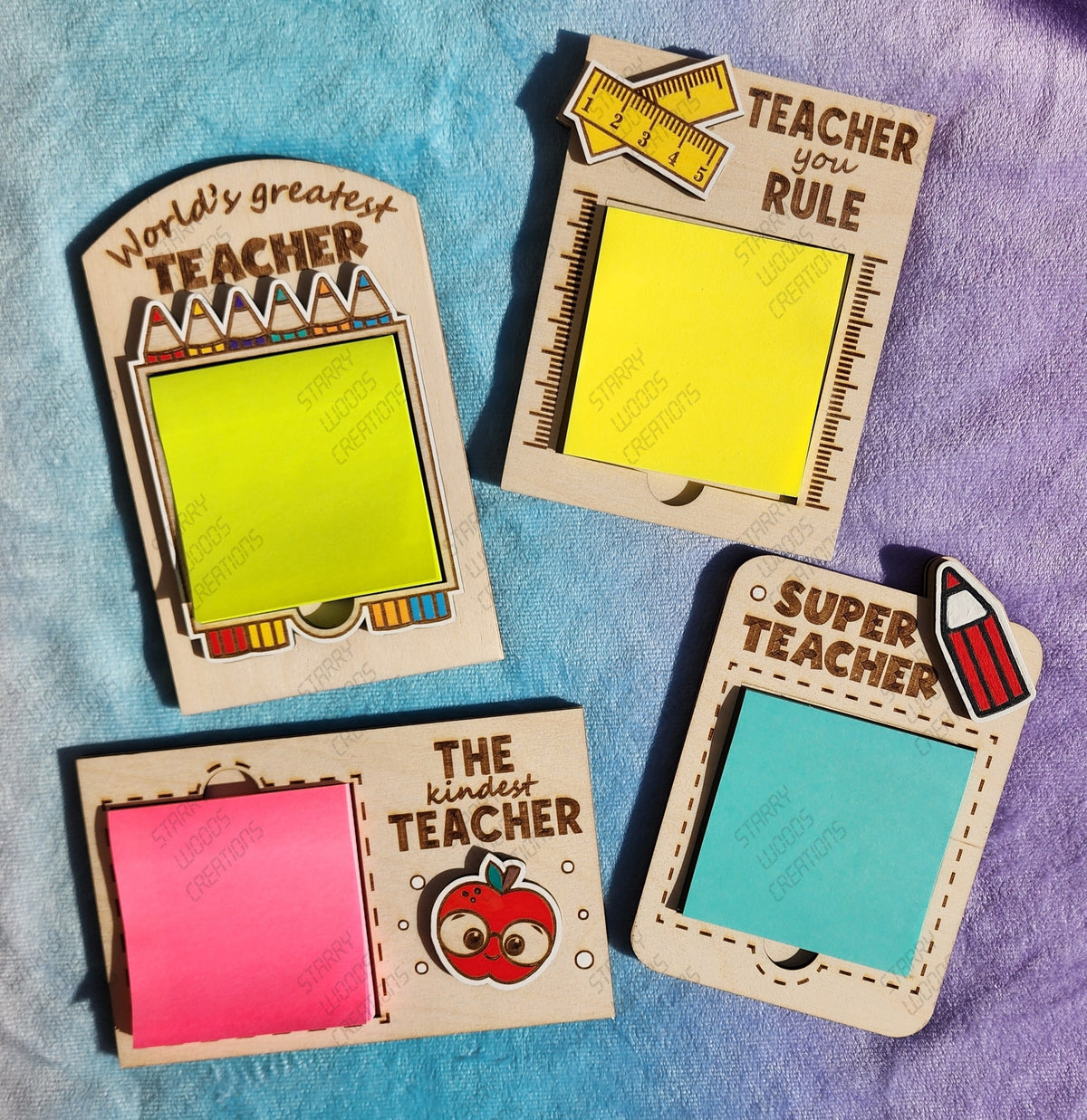 A collection of four Teacher Post-It Note Holders in various colors with decorative text and illustrations, displayed against a purple background. Customizable engraving and colour choices.
