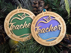 Two wooden ornaments with 'Teacher' text on a Christmas tree, colour background on the ornaments is customizable